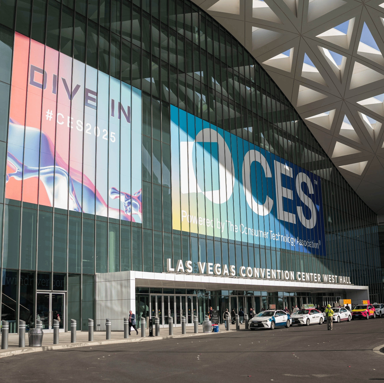 Exterior of the Las Vegas Convention Center West Hall featuring large CES 2025 banners.