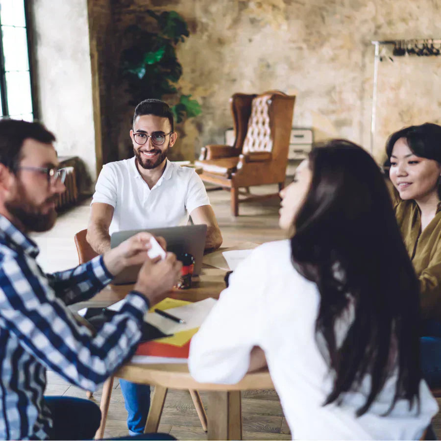 Professionals in a meeting using a white Plaud Note AI voice recorder for transcription.