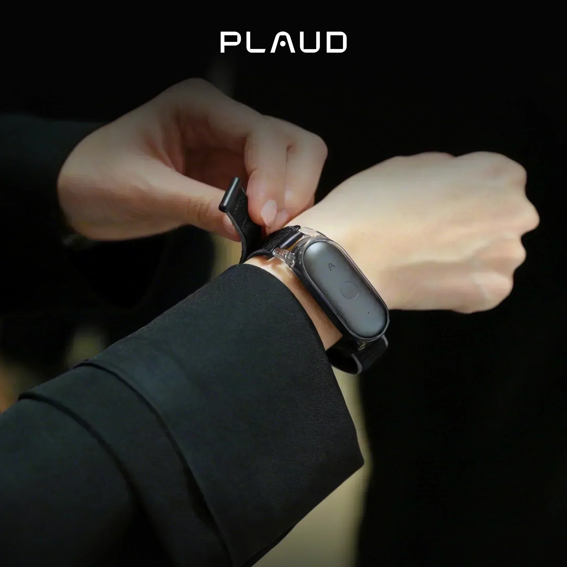 Person wearing a black Plaud NotePin on a wristband accessory.