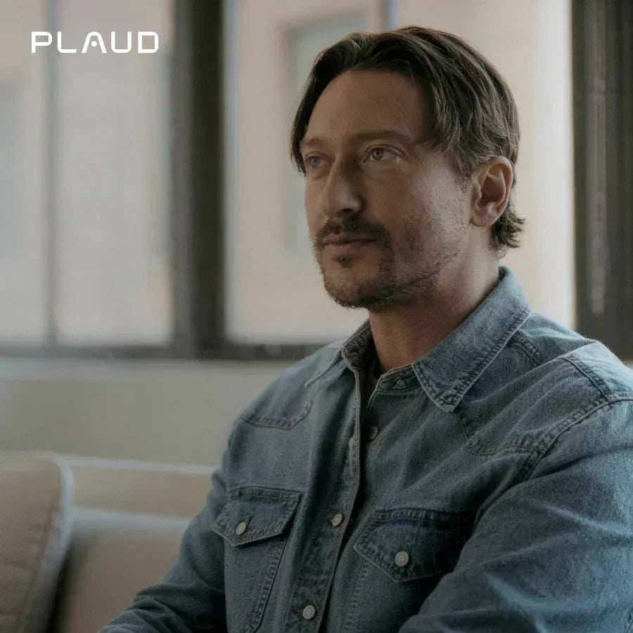 A man in a blue denim shirt looking thoughtfully to the side, featuring the Plaud logo.
