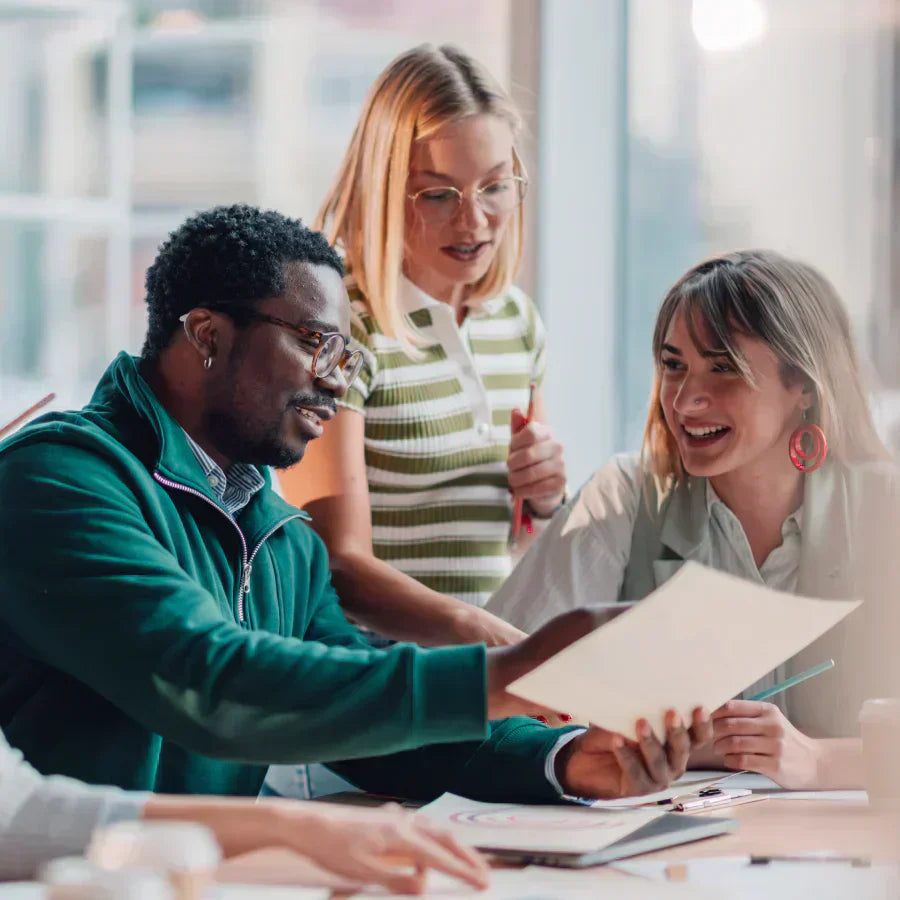 A diverse team collaborating in a meeting with a Starlight Plaud Note AI voice recorder on the table.