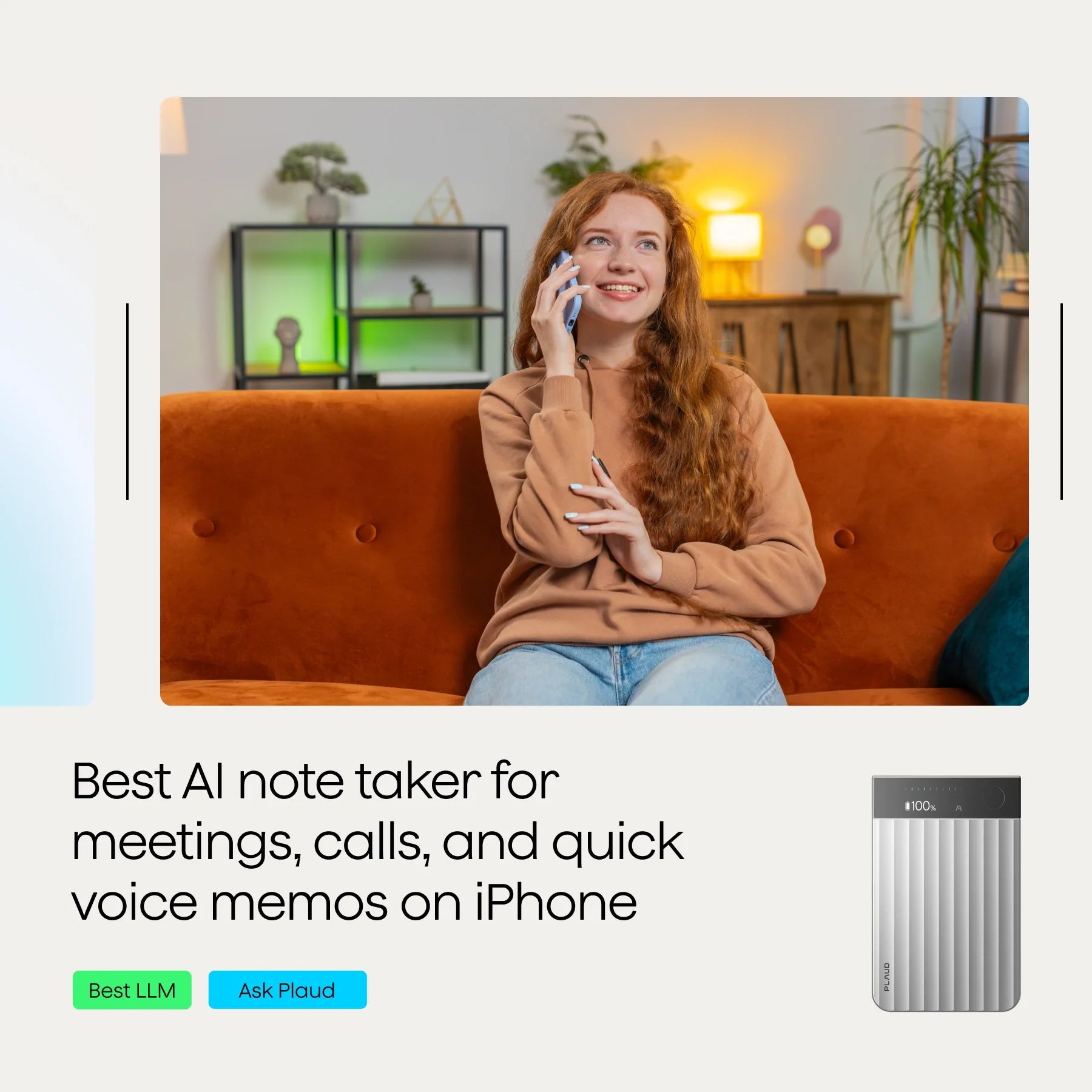 A person with long red hair wearing a brown hoodie is sitting on an orange couch, smiling while talking on a smartphone.