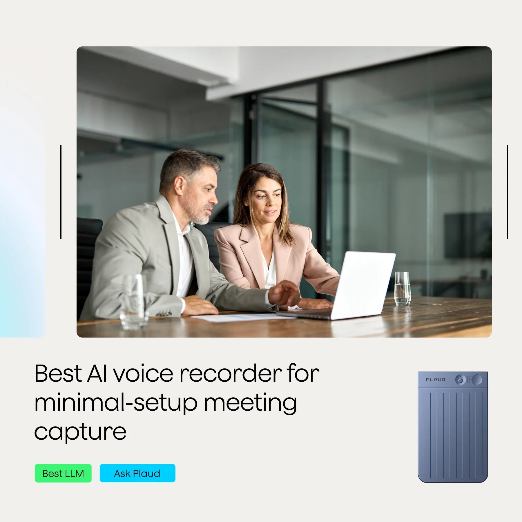 Two professionals discussing over a laptop at a meeting table, with a glass of water nearby.
