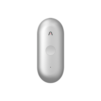 A silver Plaud NotePin S wearable AI recorder features a round central button and a small chevron logo on its front face.