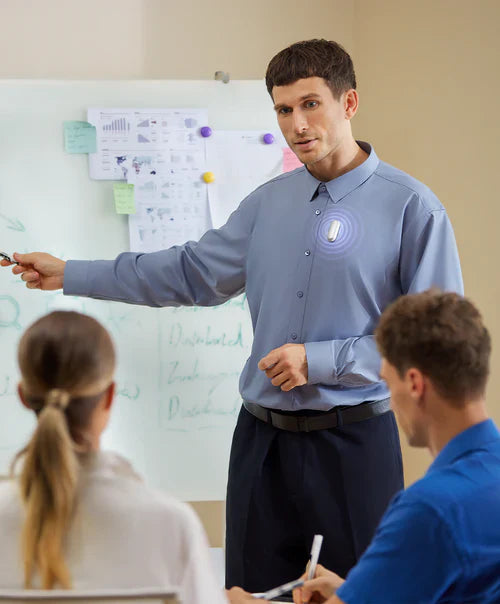 Professional wearing a silver Plaud NotePin on his shirt while presenting in a meeting.
